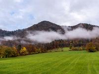 Wolkenband an den herbstlichen Berghängen bei Aschau